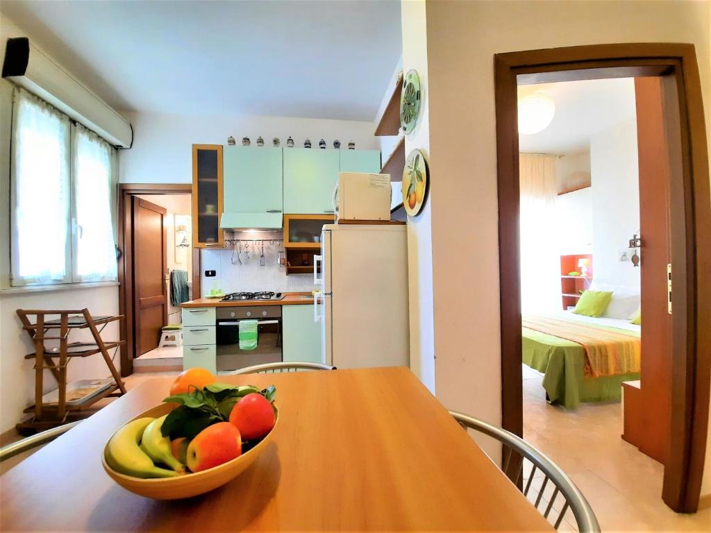 阿爾蓋羅的住宿－Casa Alice，厨房配有一张桌子,上面放着一碗水果