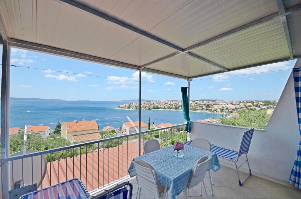 a table on a balcony with a view of the ocean at Apartments Petar in Trogir