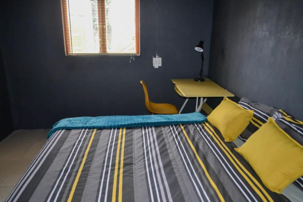 a bedroom with a bed with a desk and a table at Phola at my place in Durban