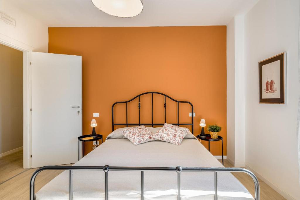 1 dormitorio con 1 cama con pared de color naranja en Family & Friends Rooms with shared bathroom en Padova