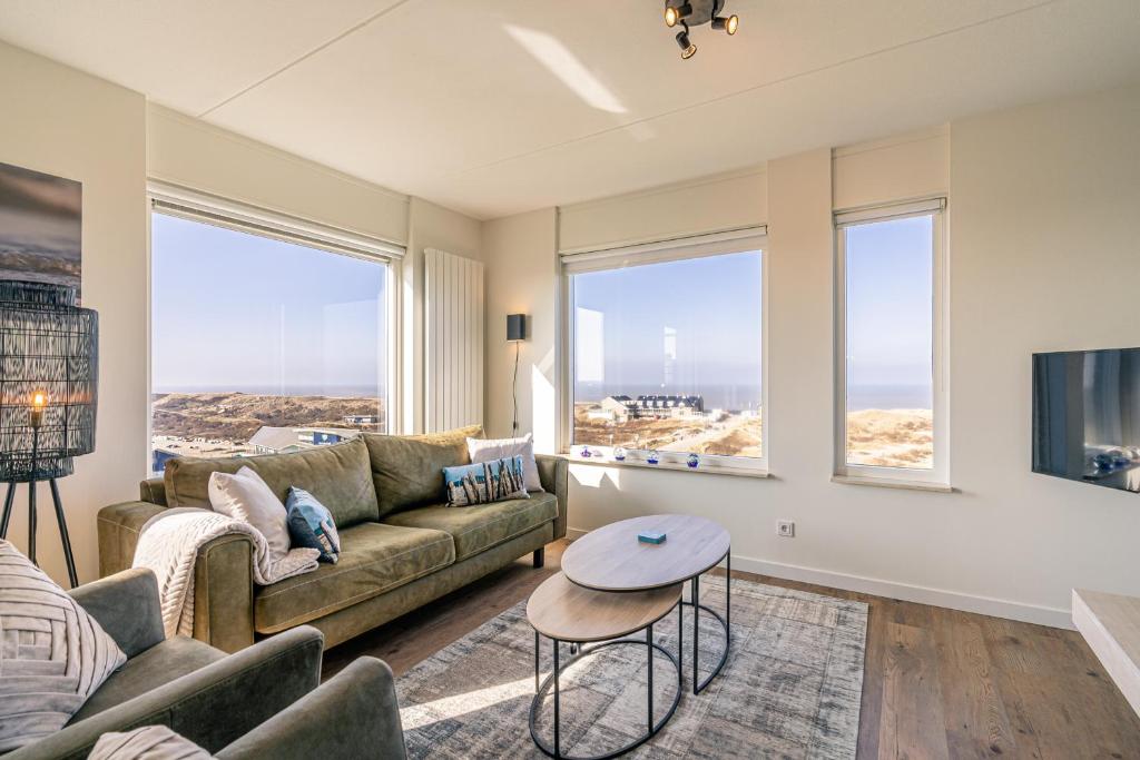 una sala de estar con un sofá y una mesa en Appartementencomplex Juliana 150, en De Koog