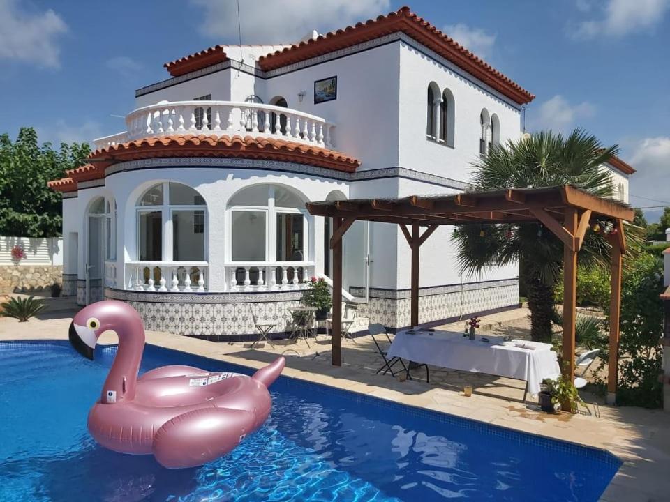 eine Villa mit einem Pool vor einem Haus in der Unterkunft casa Costa Dorada in Les tres Cales