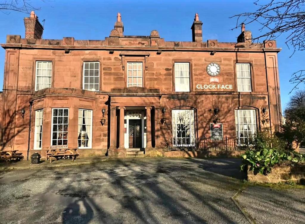 a large brick building with a clock on it at The Clock Face Prescot in Prescot