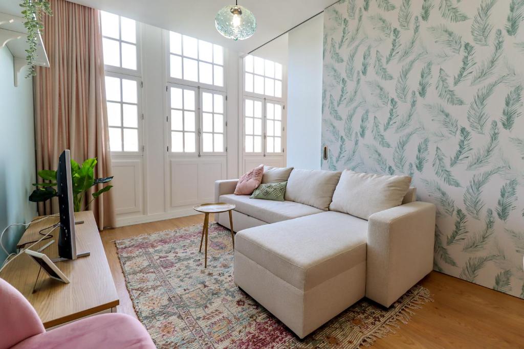 a living room with a couch and a tv at Santa Luzia Views - Modern City Centre Apartment with Iconic Views in Viana do Castelo