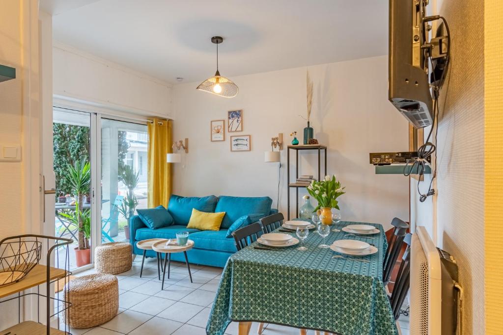 un salon avec un canapé bleu et une table dans l'établissement Le Mogador - Appartement famillial à 100m de la plage, à Arcachon