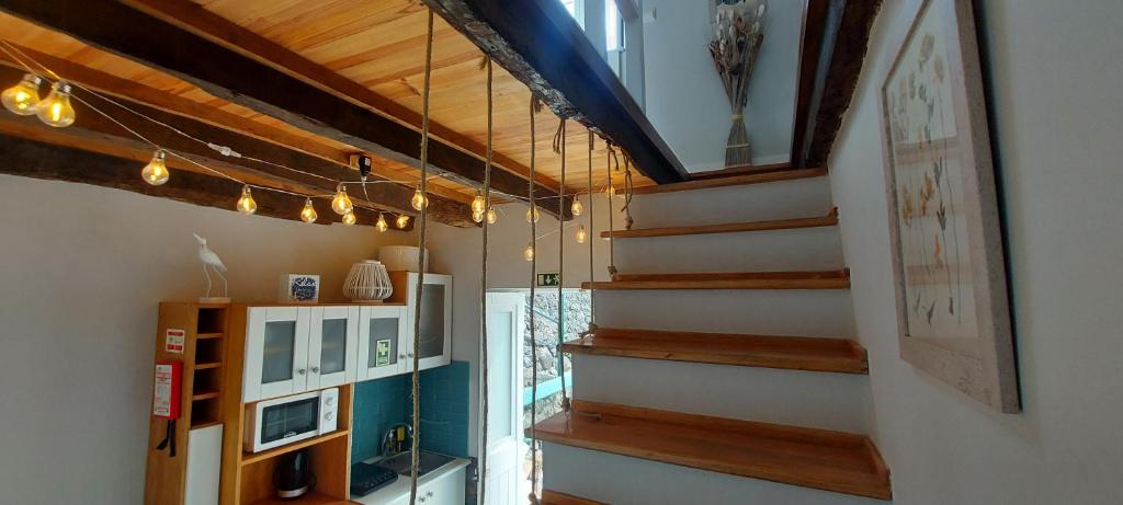 a staircase in a house with wooden ceilings at Madalena Beach Tiny House in Ponta do Sol