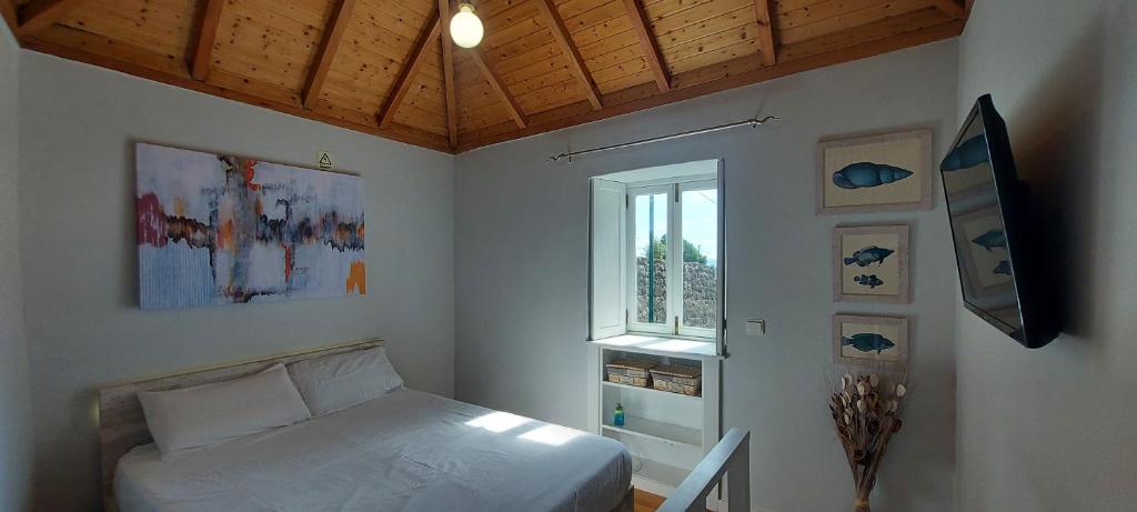 a small bedroom with a bed and a window at Madalena Beach Tiny House in Ponta do Sol