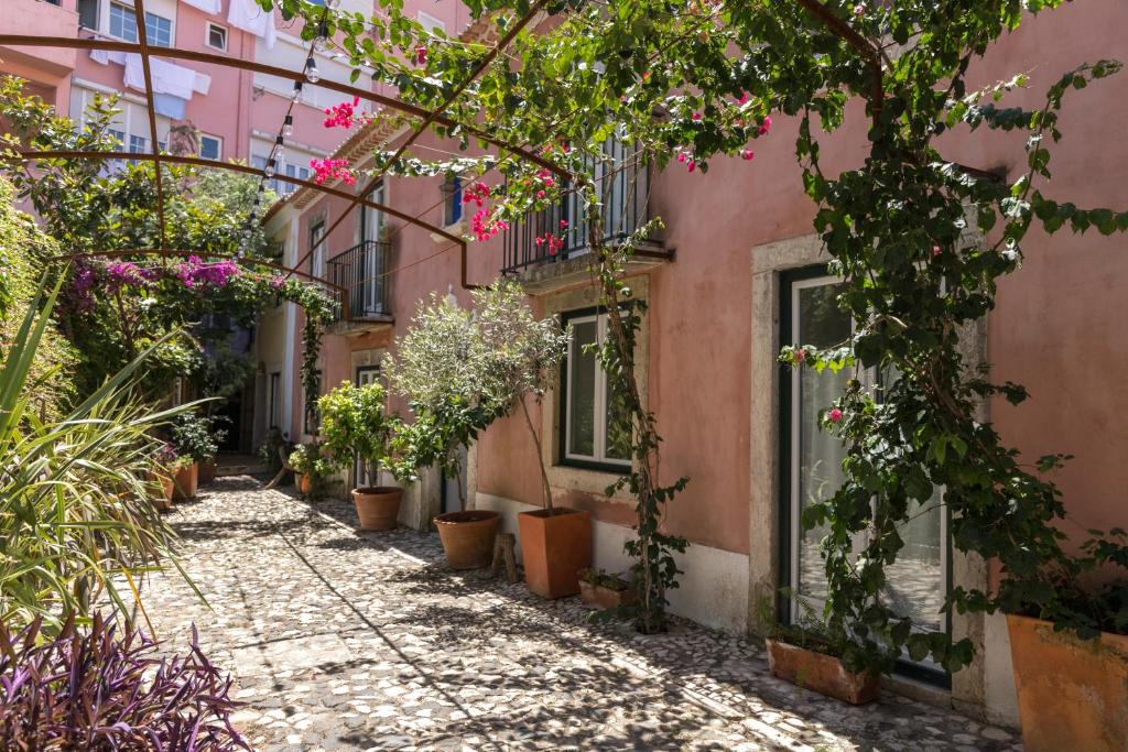 eine Gasse in einer Altstadt mit Blumen in der Unterkunft Villa Domingues in Lissabon
