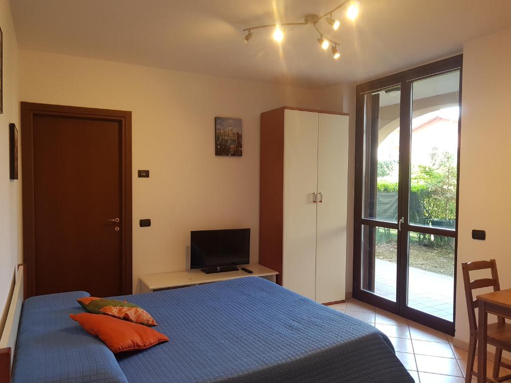 - une chambre avec un lit bleu et une télévision dans l'établissement Apartment Lake Maggiore - Elisa, à Maccagno Inferiore