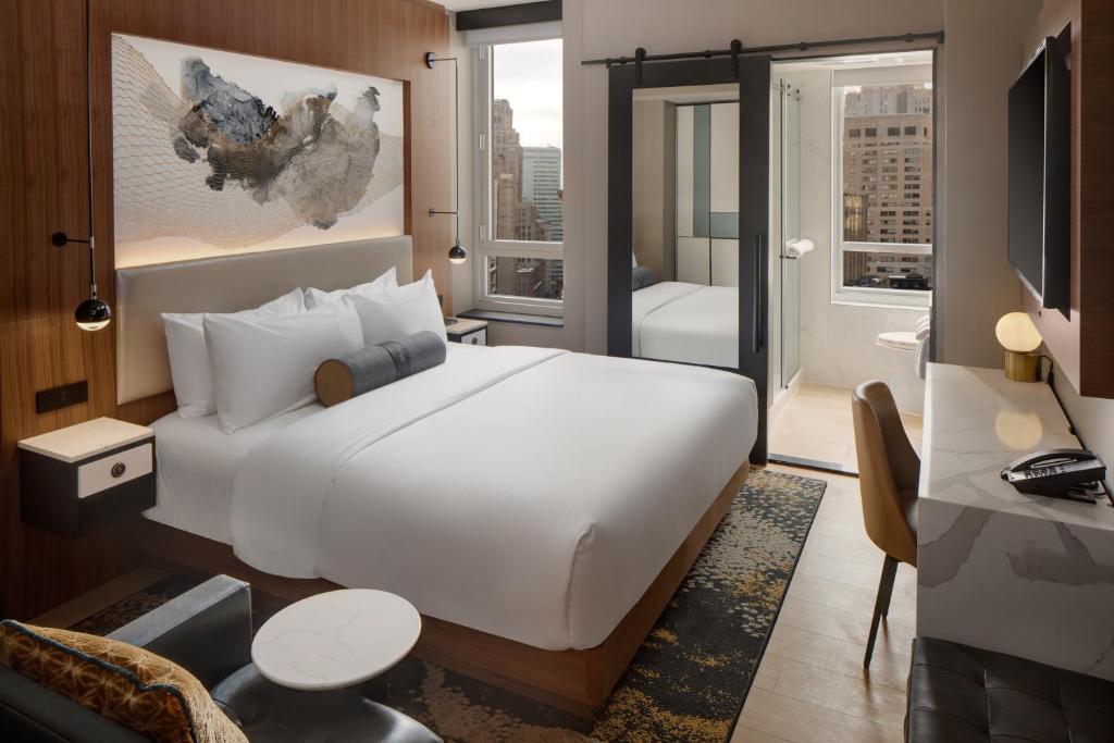 a hotel room with a large bed and a large mirror at Hotel Indigo - NYC Downtown - Wall Street, an IHG Hotel in New York