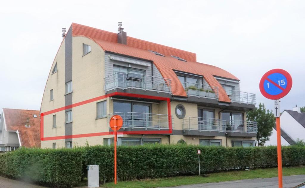 a building with an orange roof on a street at Den Oever in Middelkerke