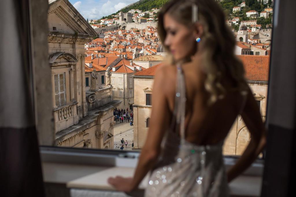 Una mujer mirando por una ventana a una ciudad en Apartment Ira, en Dubrovnik