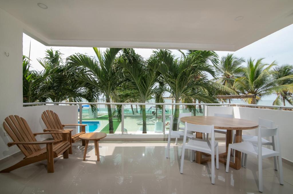 a dining room with a table and chairs and palm trees at Magico Apartamento Frente al Mar 2 Habitaciones B11A in Coveñas