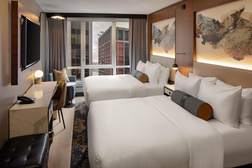 a hotel room with two beds and a window at Hotel Indigo NYC Downtown - Wall Street, an IHG Hotel in New York