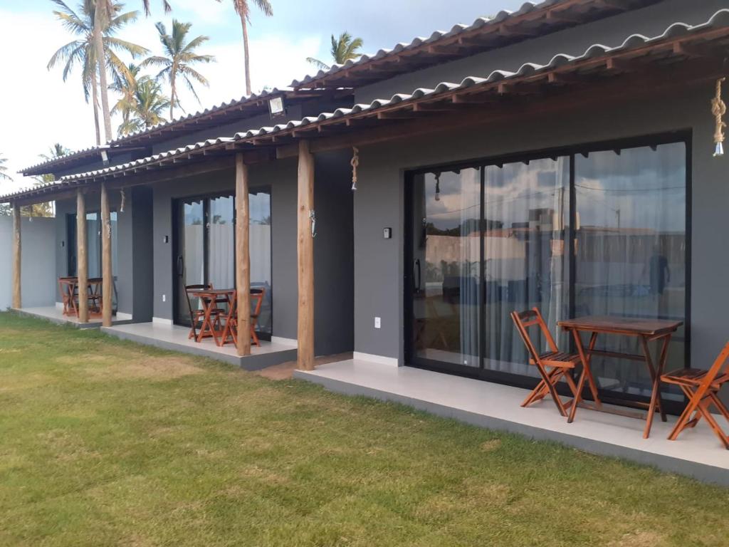 Blick auf ein Haus mit einem Tisch und Stühlen in der Unterkunft Village dos Coqueirais in São Miguel do Gostoso