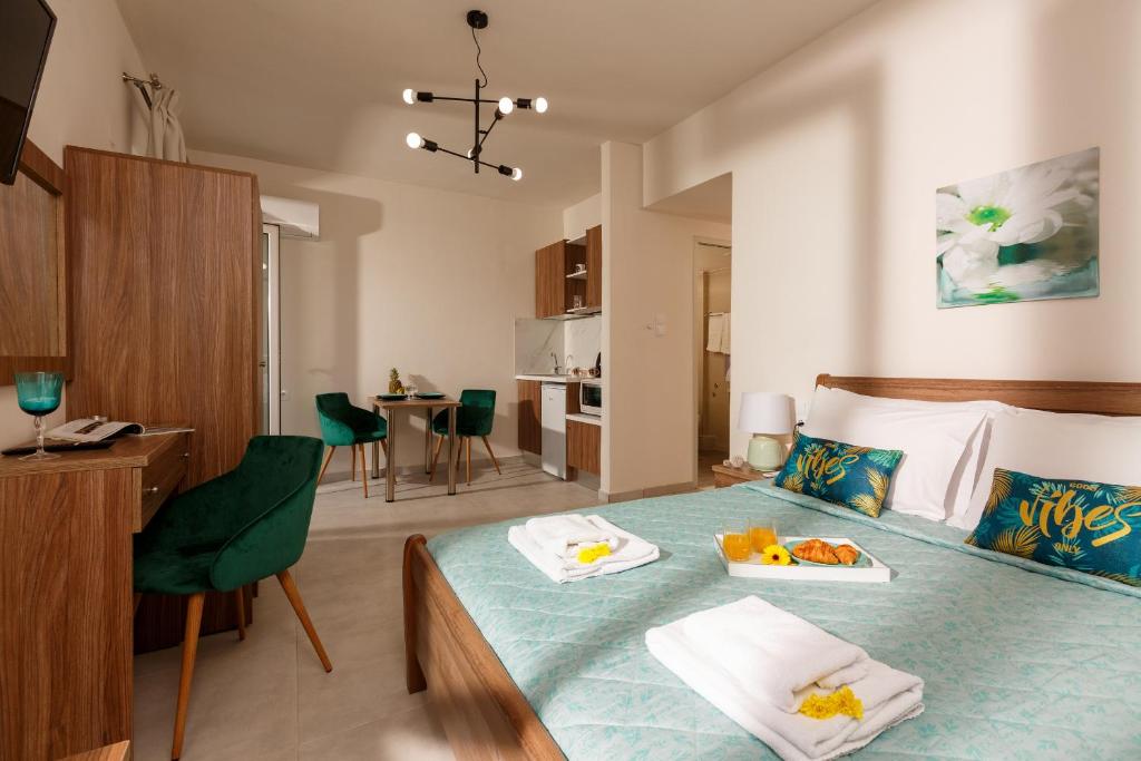 a bedroom with a bed with two plates of food on it at Asterion Luxury Studios Airport in Heraklio