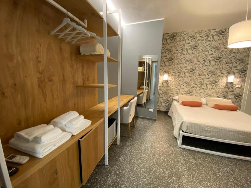 mały pokój z 2 łóżkami i lustrem w obiekcie La Taverna Antica Rooms w mieście Pescara