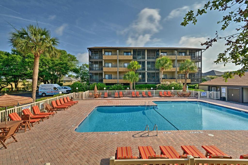 een zwembad met stoelen en een gebouw bij Condo with 2 Balconies - Across From Myrtle Beach! in Myrtle Beach