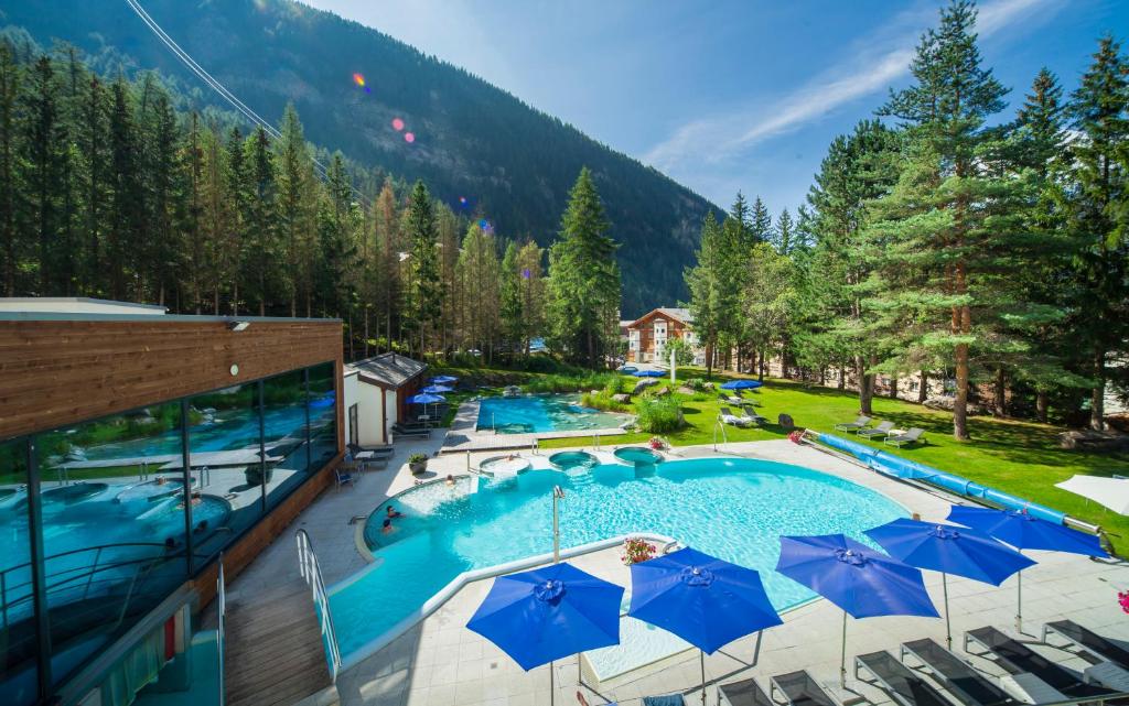 a swimming pool with a pool table and chairs at Le Bristol Leukerbad in Leukerbad