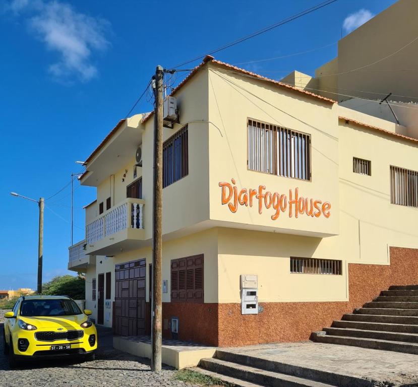 a yellow car parked in front of a building at Djarfogo house in S&atilde;o Filipe