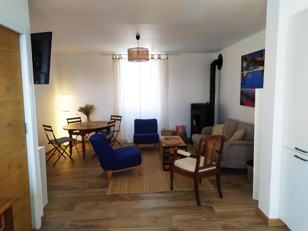 ein Wohnzimmer mit einem Tisch und Stühlen in der Unterkunft Maison rénovée avec jardin proche grande plage in Quiberon