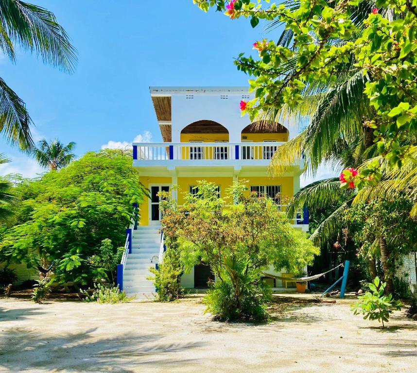 ein gelbes Haus mit blau und weiß in der Unterkunft JAGUAR MORNING STAR in Caye Caulker