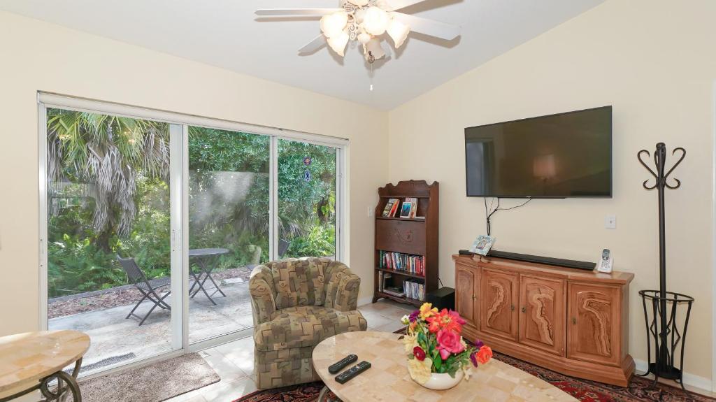 ein Wohnzimmer mit einem TV und einem Tisch in der Unterkunft Close to Beaches, Downtown, Restaurants & Parks! in Sarasota