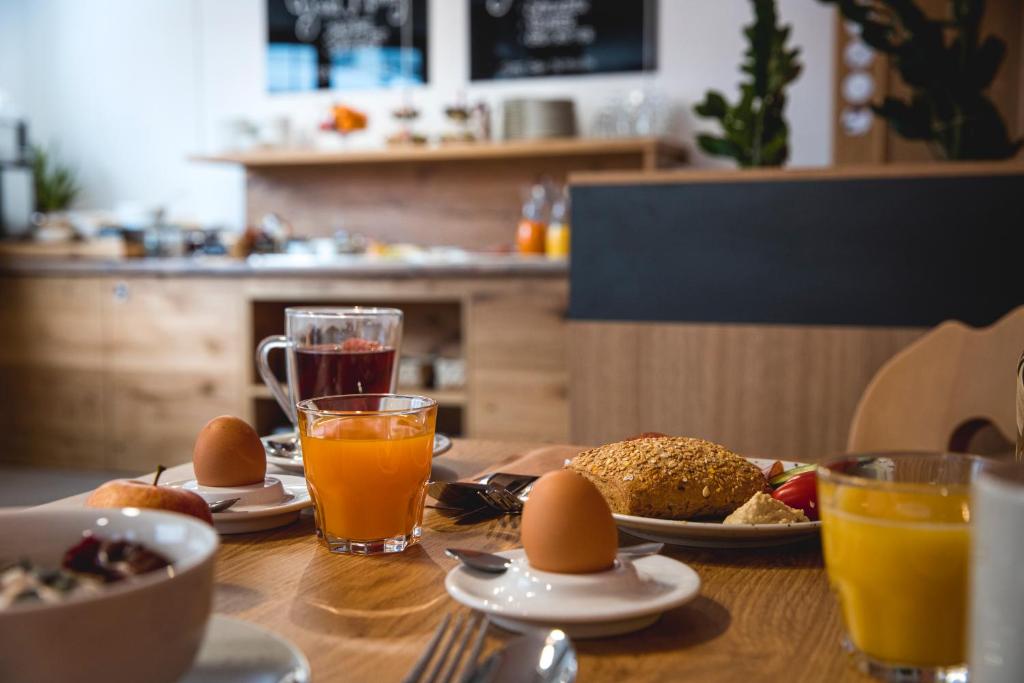 a wooden table with eggs and drinks on it at Hotel Montfort in Sankt Anton am Arlberg