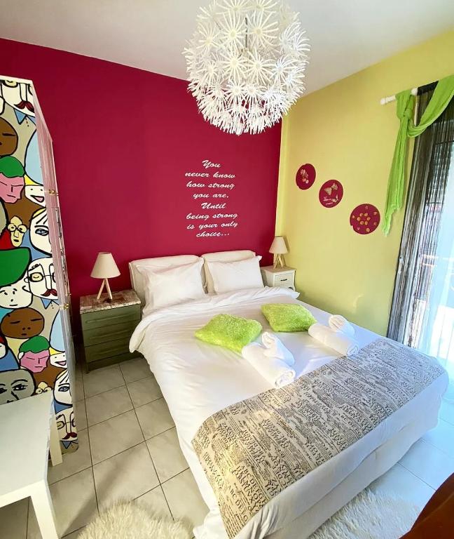 sypialnia z dużym łóżkiem i żyrandolem w obiekcie Alexandras cozy apartment Ioannina w mieście Janina