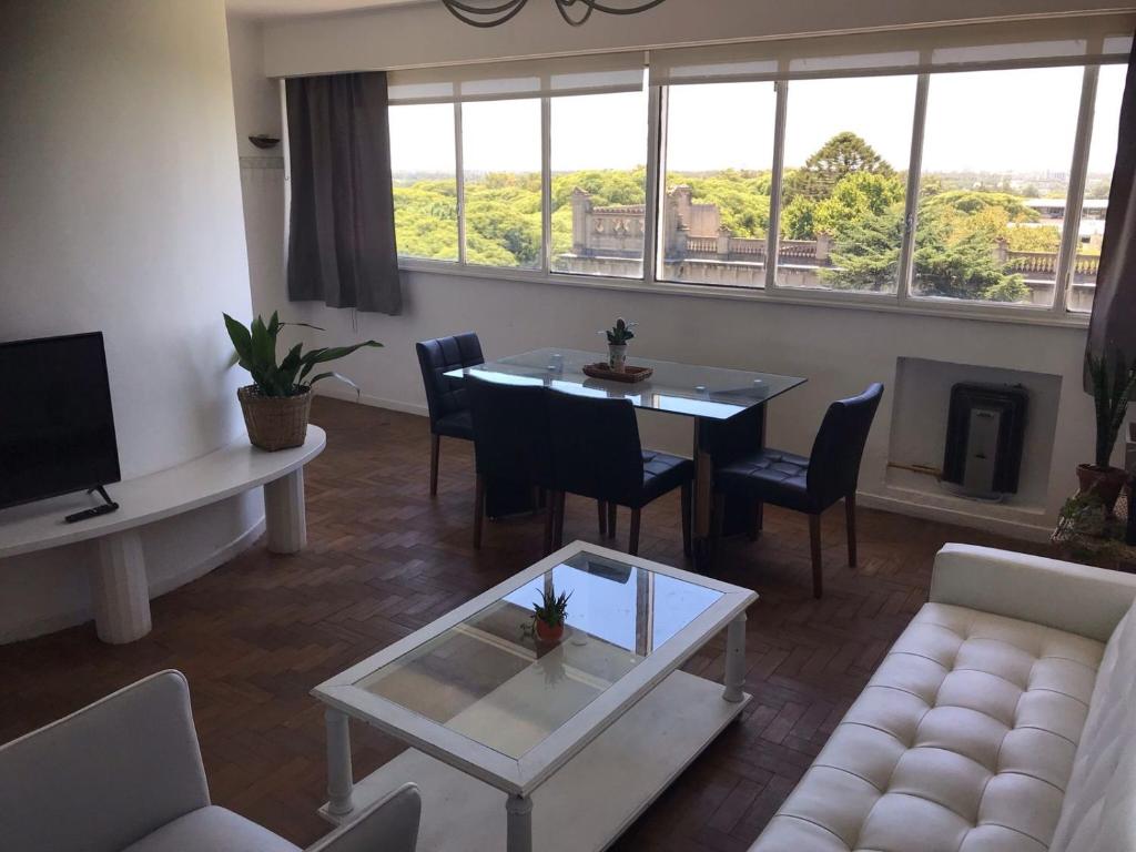 a living room with a table and chairs and a couch at Mira Bosques 3 in La Plata