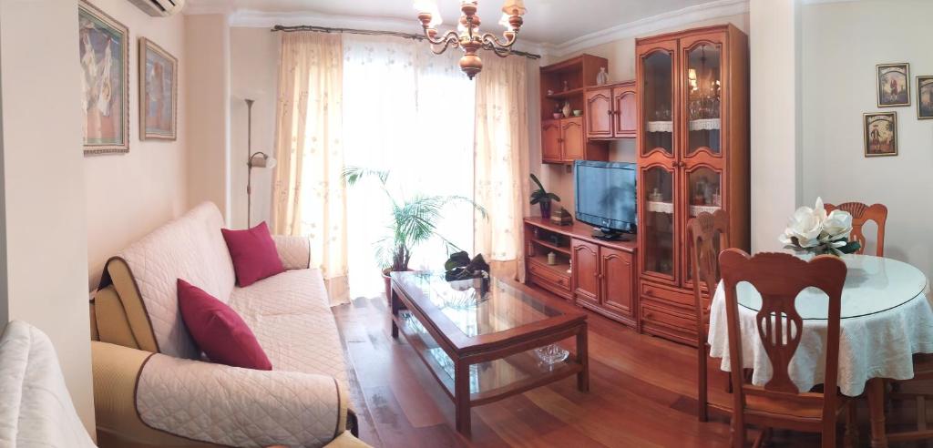 een woonkamer met een bank en een tafel bij APARTAMENTO ROZAMAR in Torre del Mar