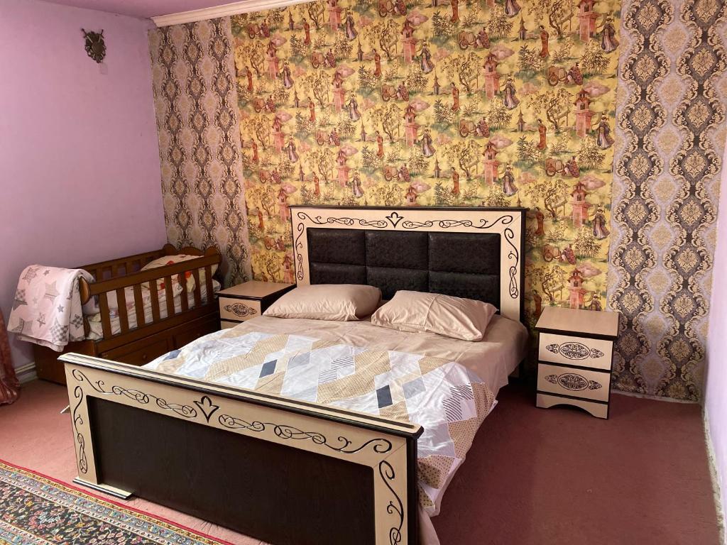 a bedroom with a bed and a wall with floral wallpaper at Friend's House rooms near Airport in Yerevan