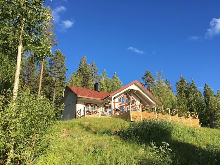 une maison au sommet d'une colline avec des arbres dans l'établissement Cozy house in Järvsö with a stunning view, à Ljusdal