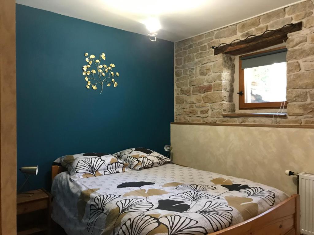 une chambre avec un lit et un mur bleu dans l'établissement Ch'ti NID au pays des lacs, à Alièze