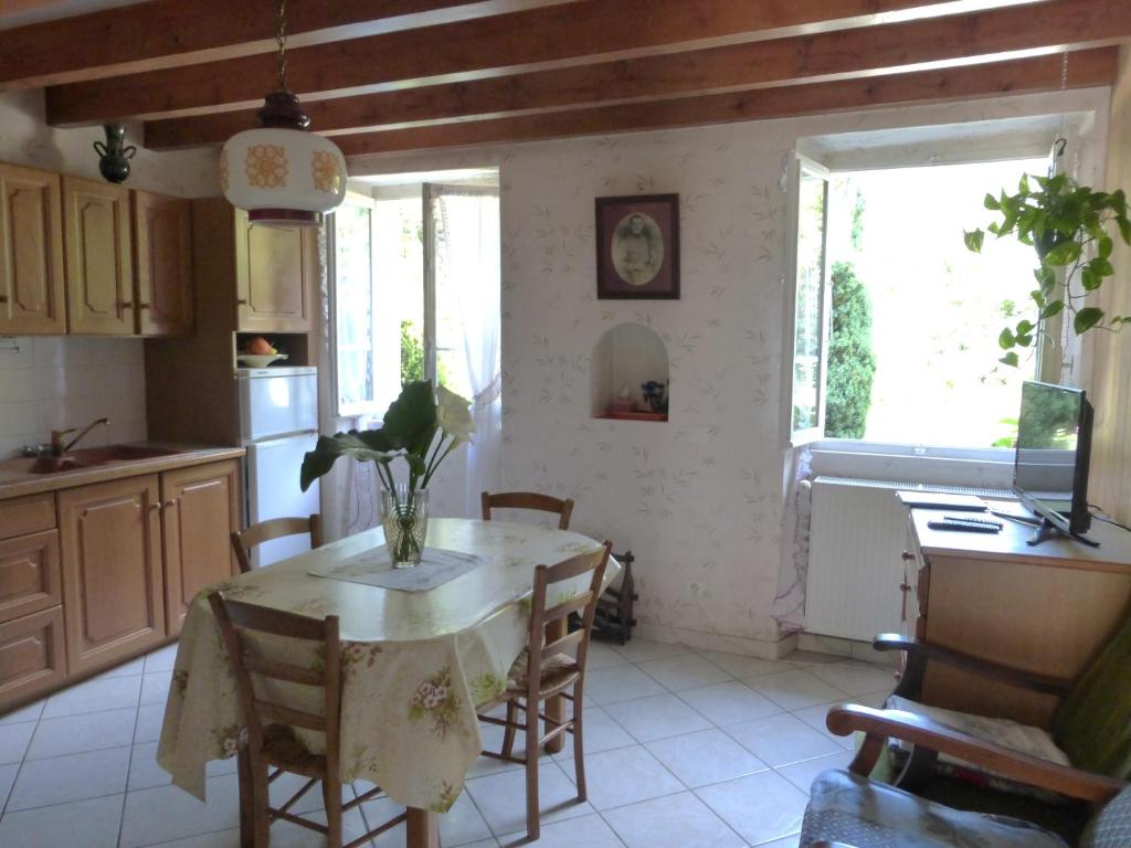 une cuisine avec une table avec un vase dessus dans l'établissement Au coeur de la campagne - Gite non loins d'Annecy- à 17 min d'Annecy - Tout prêt d'Aix les Bains, à Saint-Girod