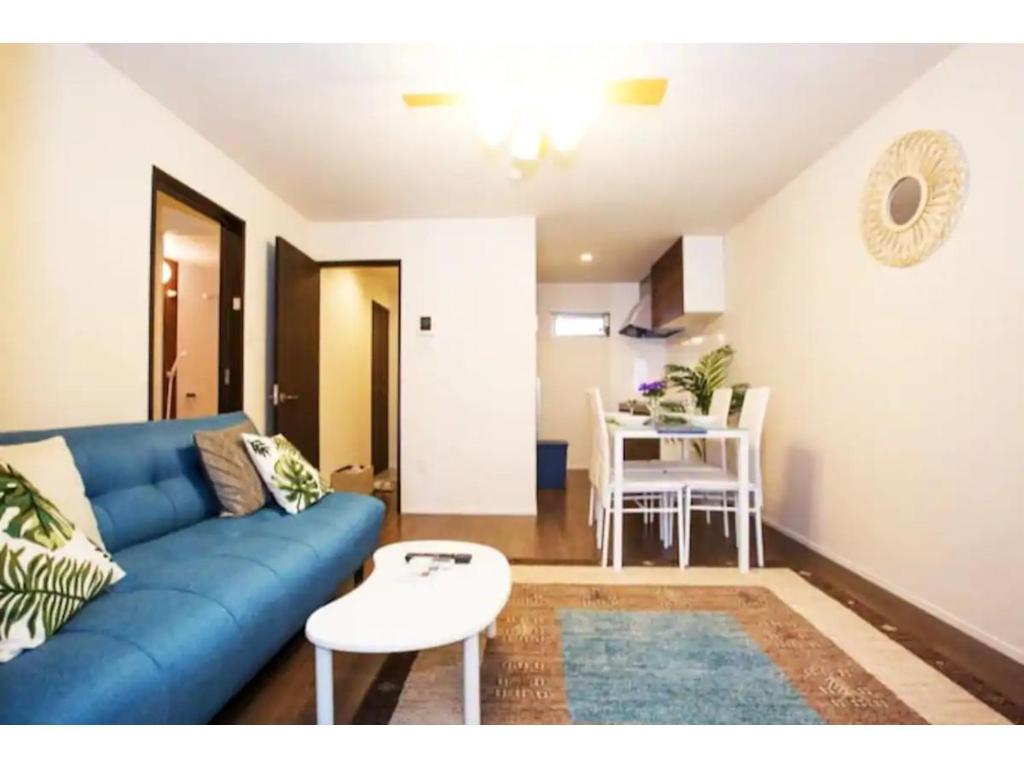 ein Wohnzimmer mit einem blauen Sofa und einem Tisch in der Unterkunft Hill Top Hakone Iryuda 202 - Vacation STAY 11214 in Odawara