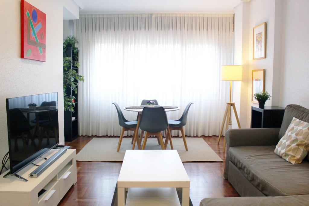 Bilbao Apartment Lasai con parking directo في بلباو: غرفة معيشة مع أريكة وطاولة