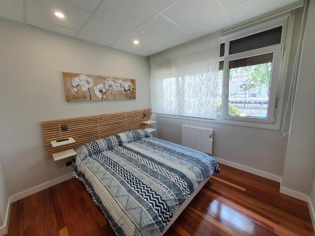 a bedroom with a bed and a window at Pensión Guggenheim Riverview HBI01297 in Bilbao
