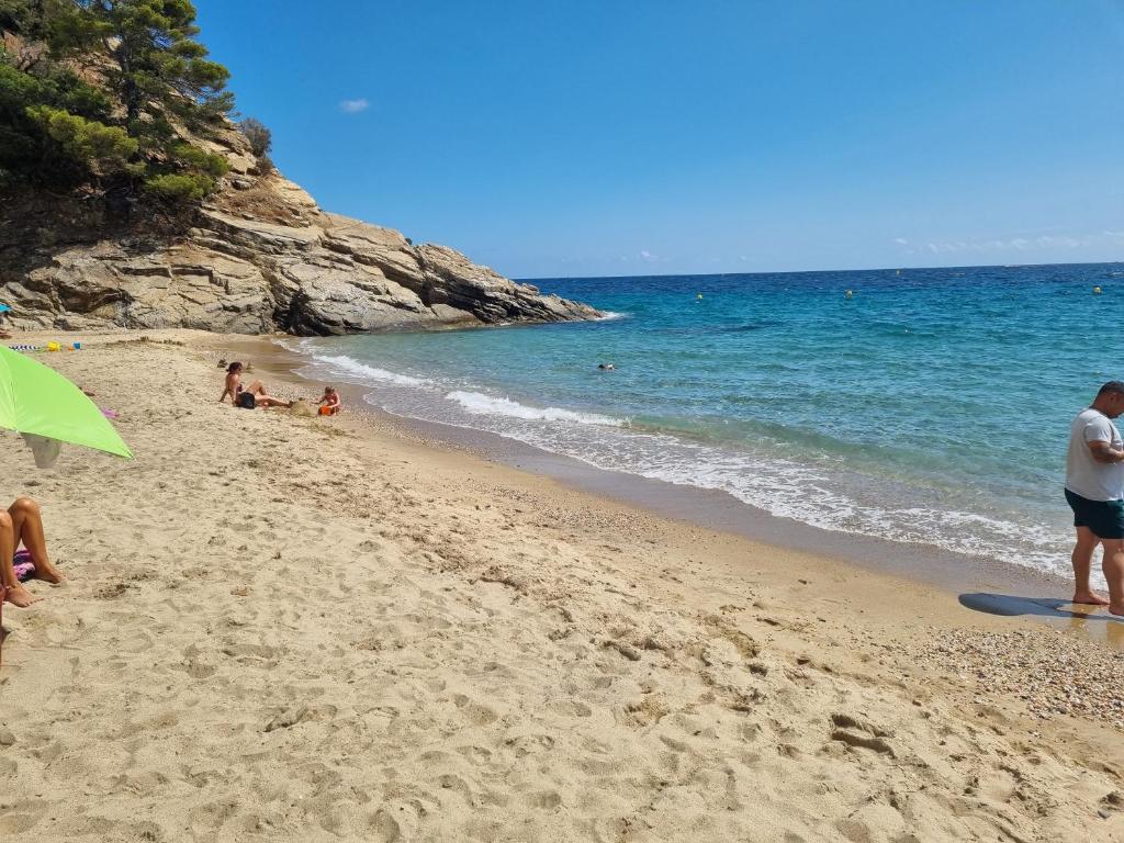 a group of people on a beach near the ocean at Le jardin de Bonporteau in Cavalaire-sur-Mer