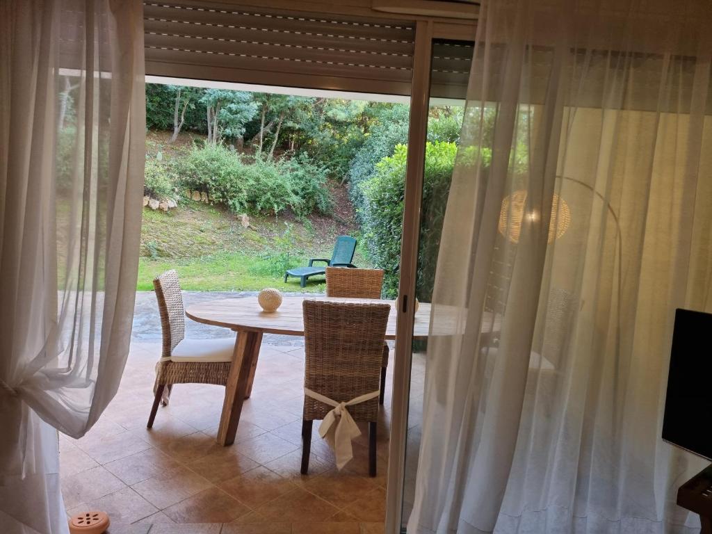 ein Esszimmer mit einem Tisch, Stühlen und einem Fenster in der Unterkunft Le jardin de Bonporteau in Cavalaire-sur-Mer