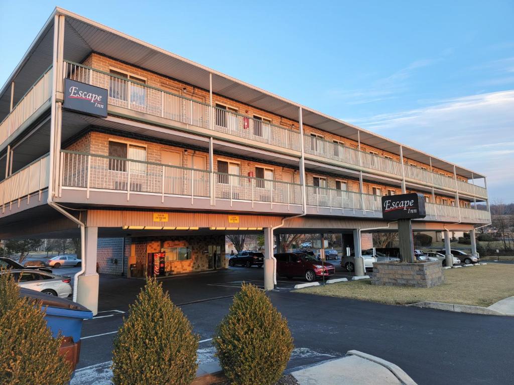 un gran edificio con coches estacionados en un estacionamiento en Escape Inn Hershey en Hershey