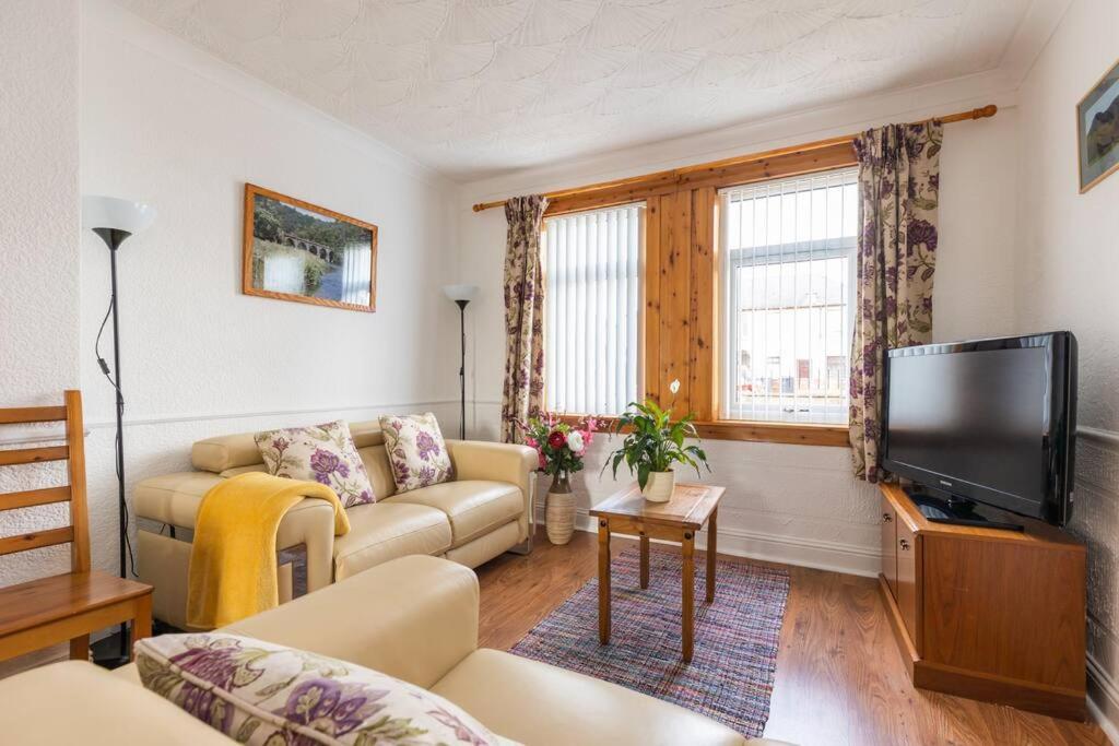 un soggiorno con divano e TV a schermo piatto di Beautiful 2 bedroom flat in Edinburgh a Edimburgo