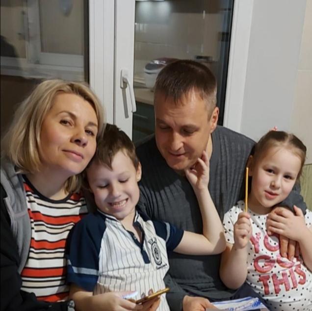 a man and a woman and two children sitting on a couch at Apartment On Khreshchatyk 21 in Kyiv