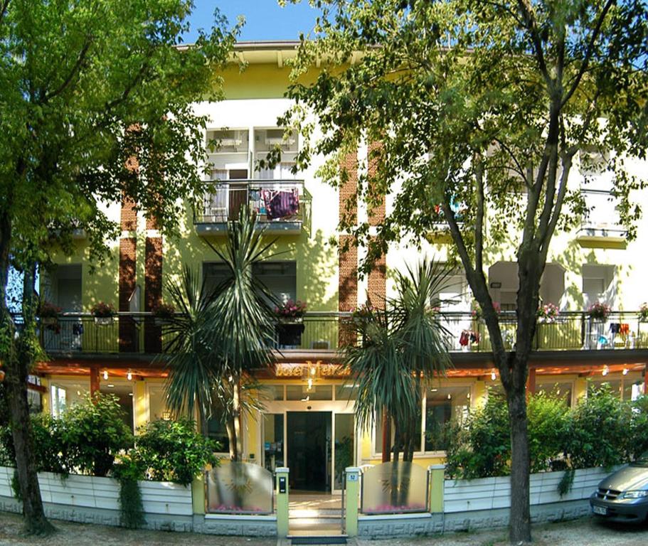 un edificio con palme di fronte ad esso di Hotel Metron a Cesenatico