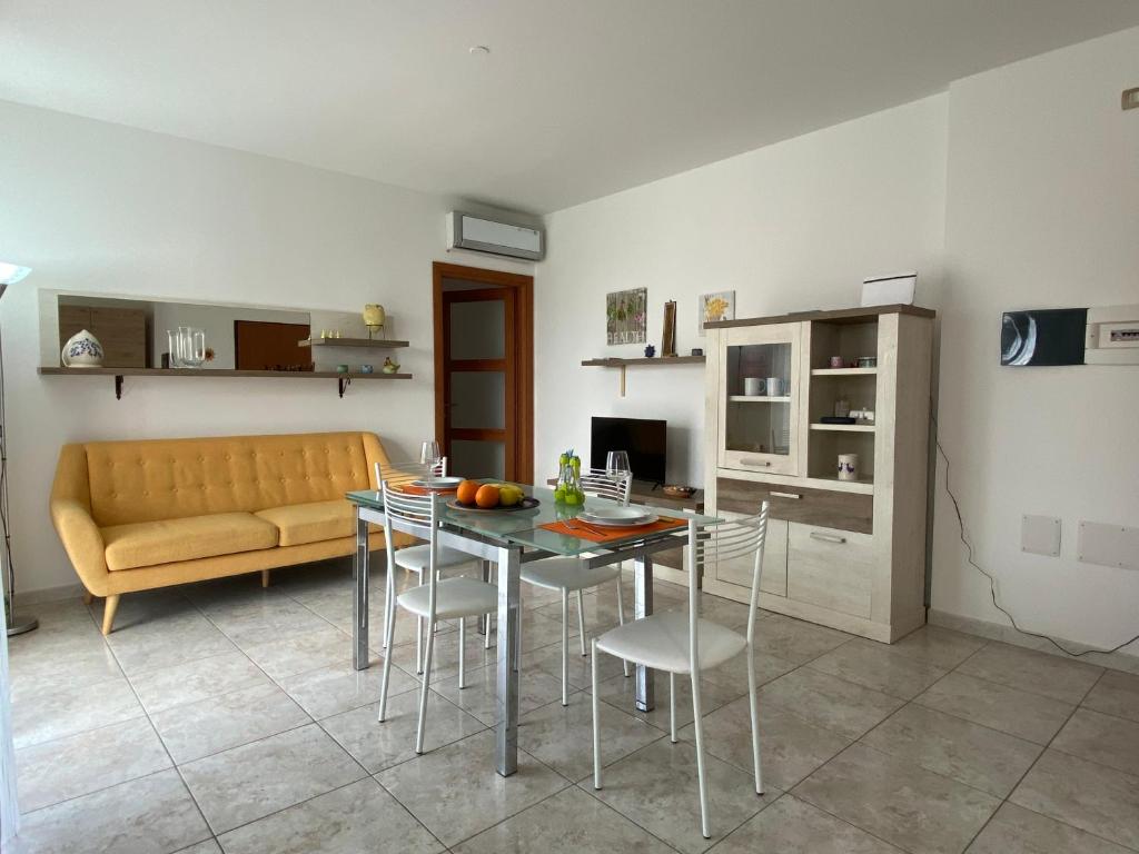 salon ze stołem, krzesłami i kanapą w obiekcie appartamento w mieście Porto Torres