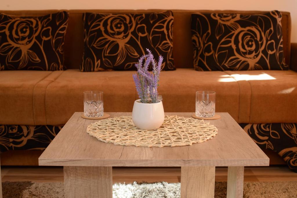 a coffee table with a vase and two glasses on it at Ante Apartment in Split