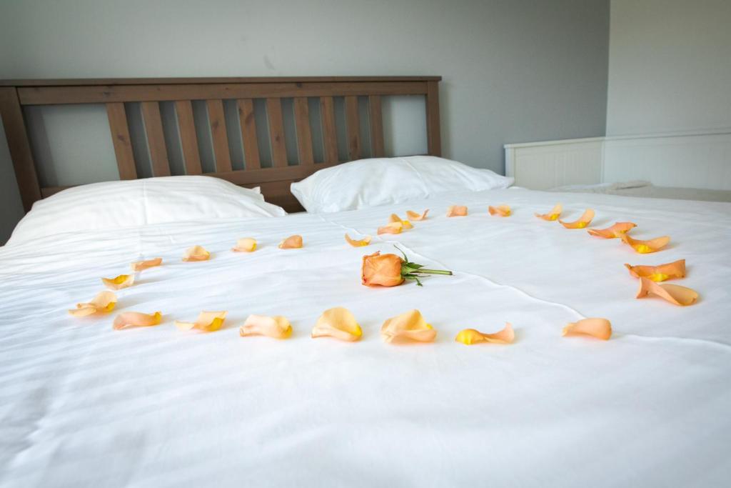 a group of roses laying on a bed at SAND Apartment in Žilina