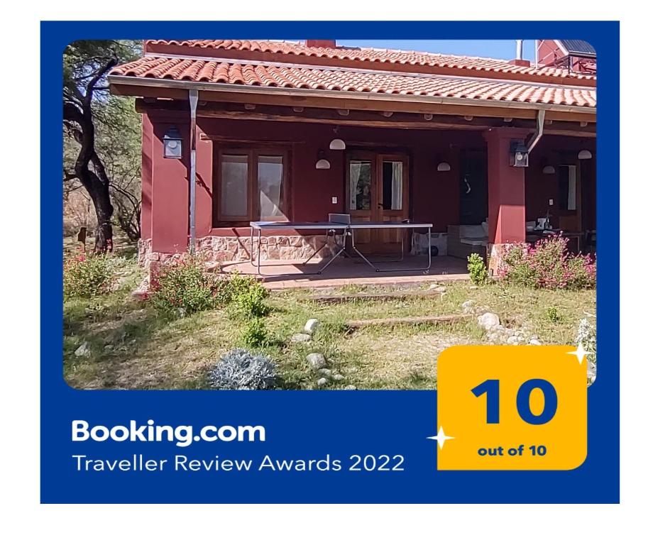 une maison rouge avec une table devant dans l'établissement La Morada, imperdible Casa de Campo en La Matilde, à San Javier