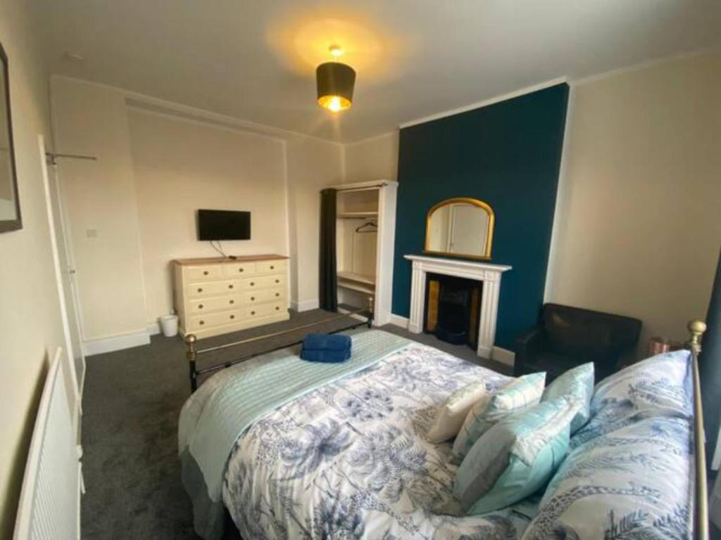 a bedroom with a large bed and a fireplace at 8 Bedroom House For Corporate Stays in Kettering in Kettering