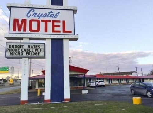 ein Motelschild vor einem Parkplatz in der Unterkunft CRYSTAL MOTEL in Tulsa